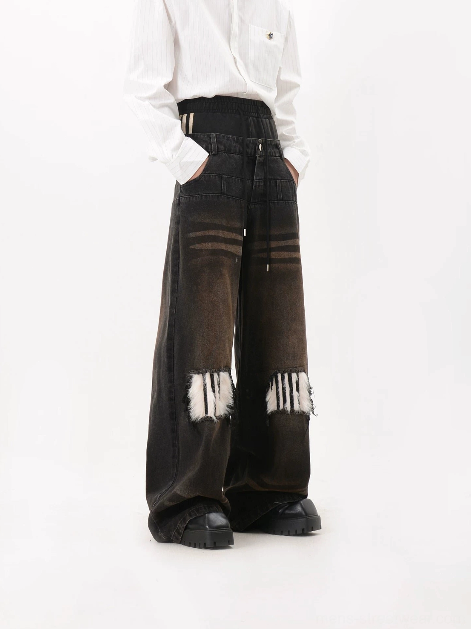 Left three quarter view of washed black faux fur patch wide leg jeans with gradient denim, distressed furry knees, layered waistband, white shirt and chunky platform shoes
