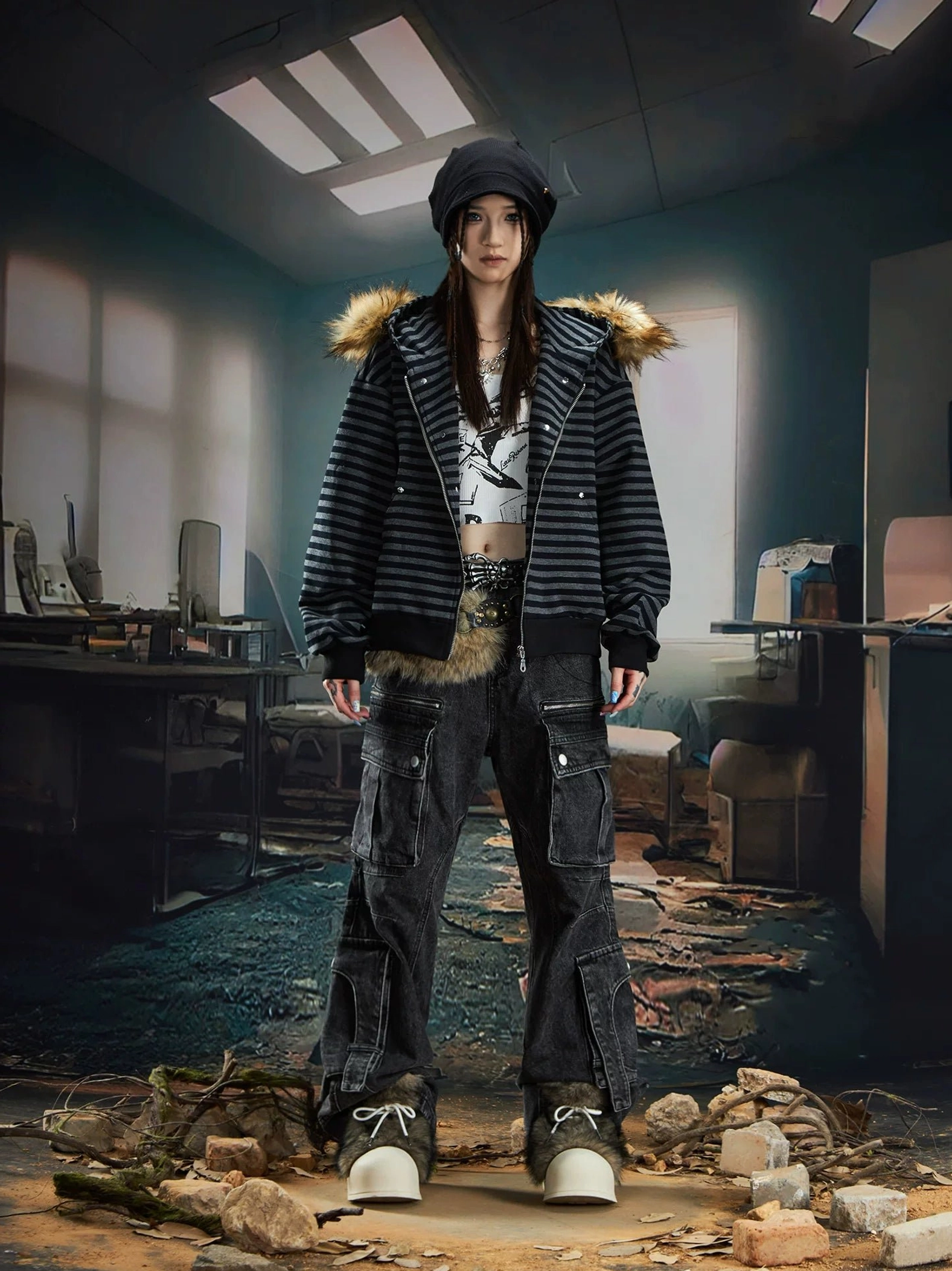 Female model wearing black and grey striped faux fur trim hooded zip-up jacket with cargo jeans beanie and platform sneakers