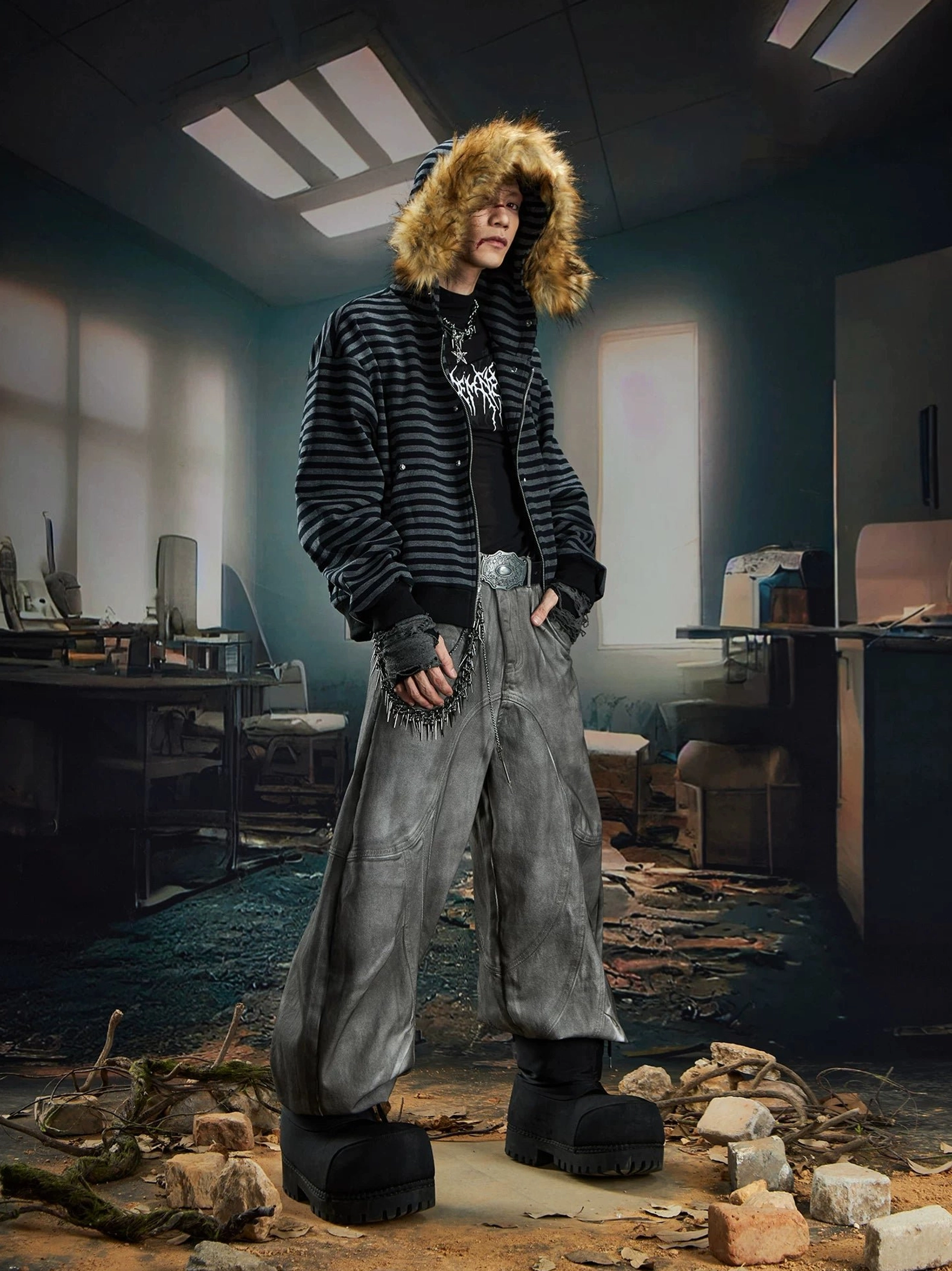 Side view of striped faux fur trim hooded zip-up streetwear jacket with hood up styled with washed grey wide-leg jeans and platform boots