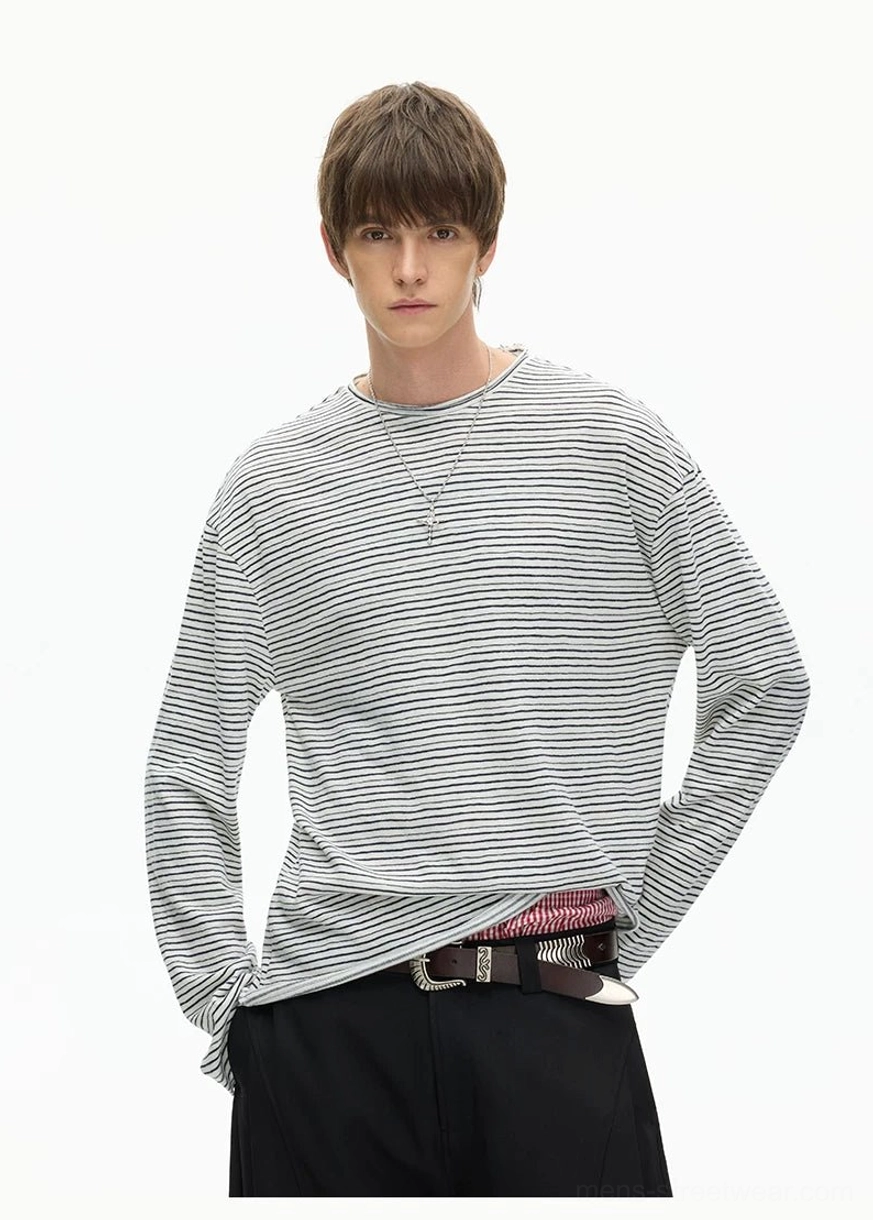 Three-quarter view of a fine stripe long sleeve crew neck tee with layered hem and modern Korean streetwear proportions
