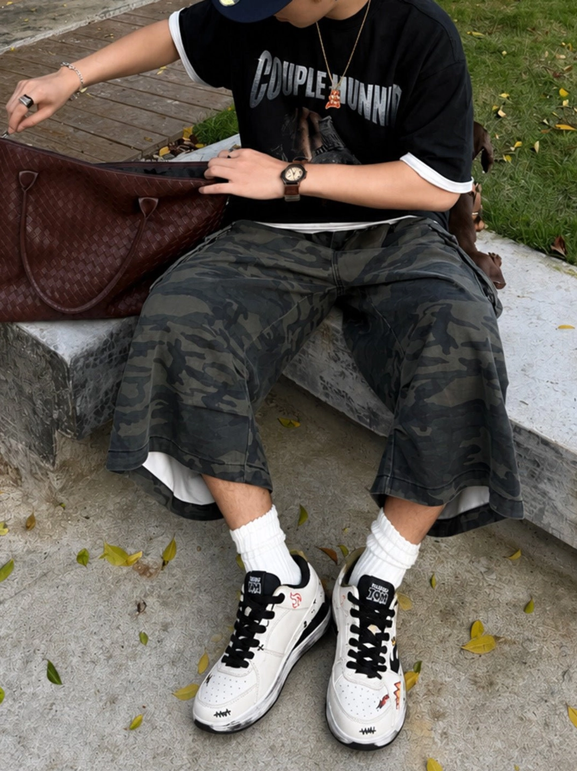 Flame graphic low-top court sneakers styled with a black graphic T-shirt and camo cargo shorts in an urban streetwear outfit