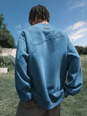 Royal blue fleece-lined script embroidered oversized crewneck sweatshirt rear view on male model outdoors