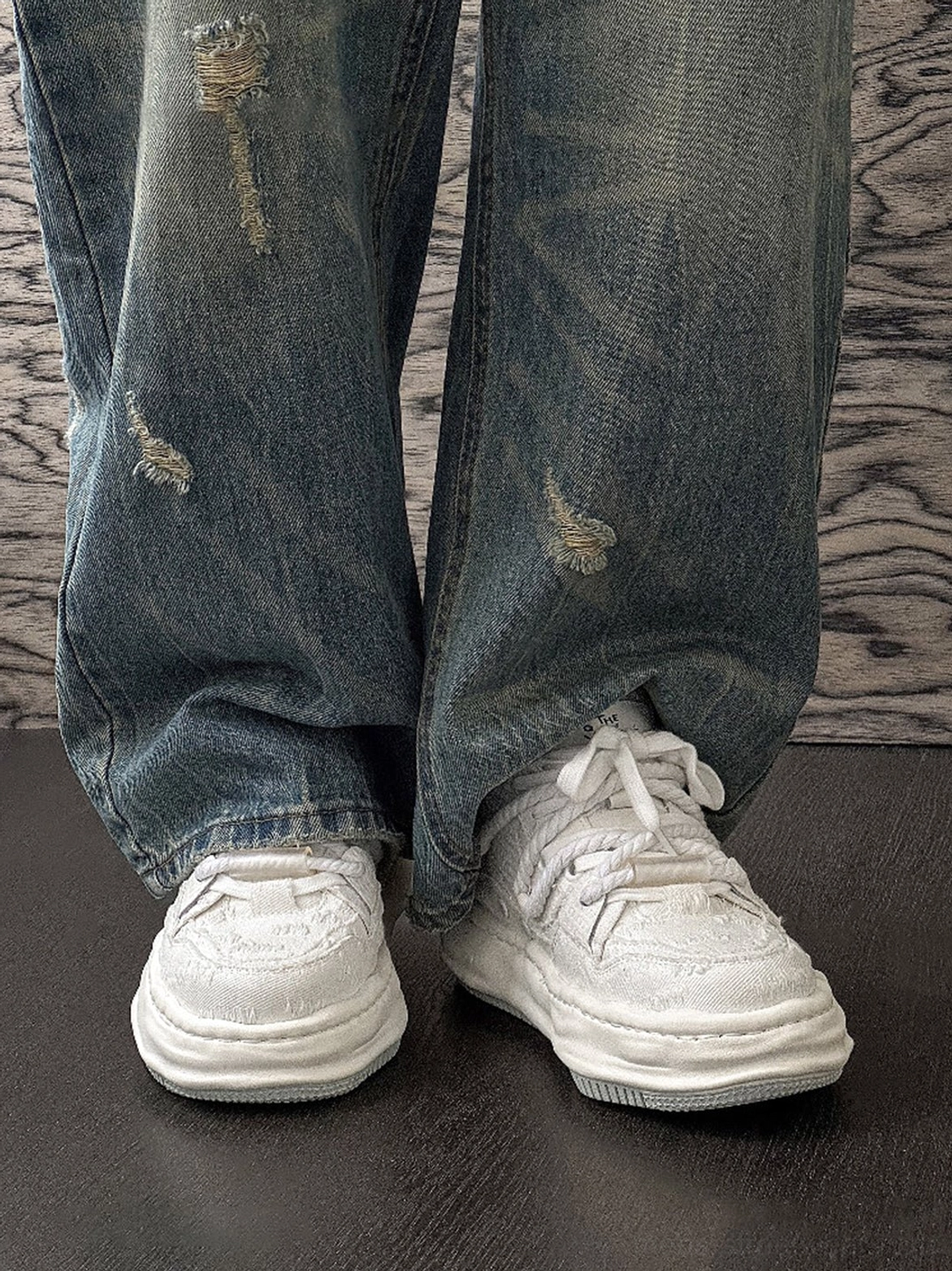 Light off-white frayed canvas platform sneakers worn with distressed straight-leg denim jeans in a low-angle Korean streetwear outfit