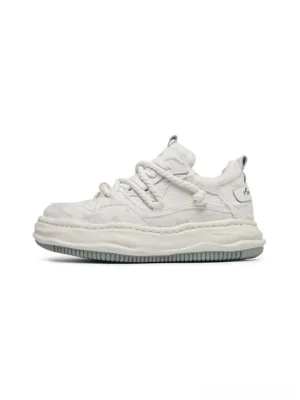 Side profile of light off-white frayed canvas platform sneakers with twisted laces, thick sculpted midsoles, and distressed Korean streetwear styling