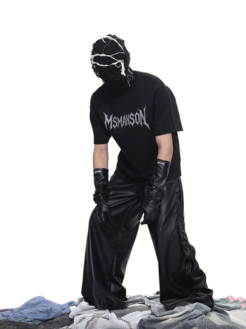 Front partial view of oversized black gothic graphic T-shirt with leather wide-leg pants and futuristic Korean streetwear styling