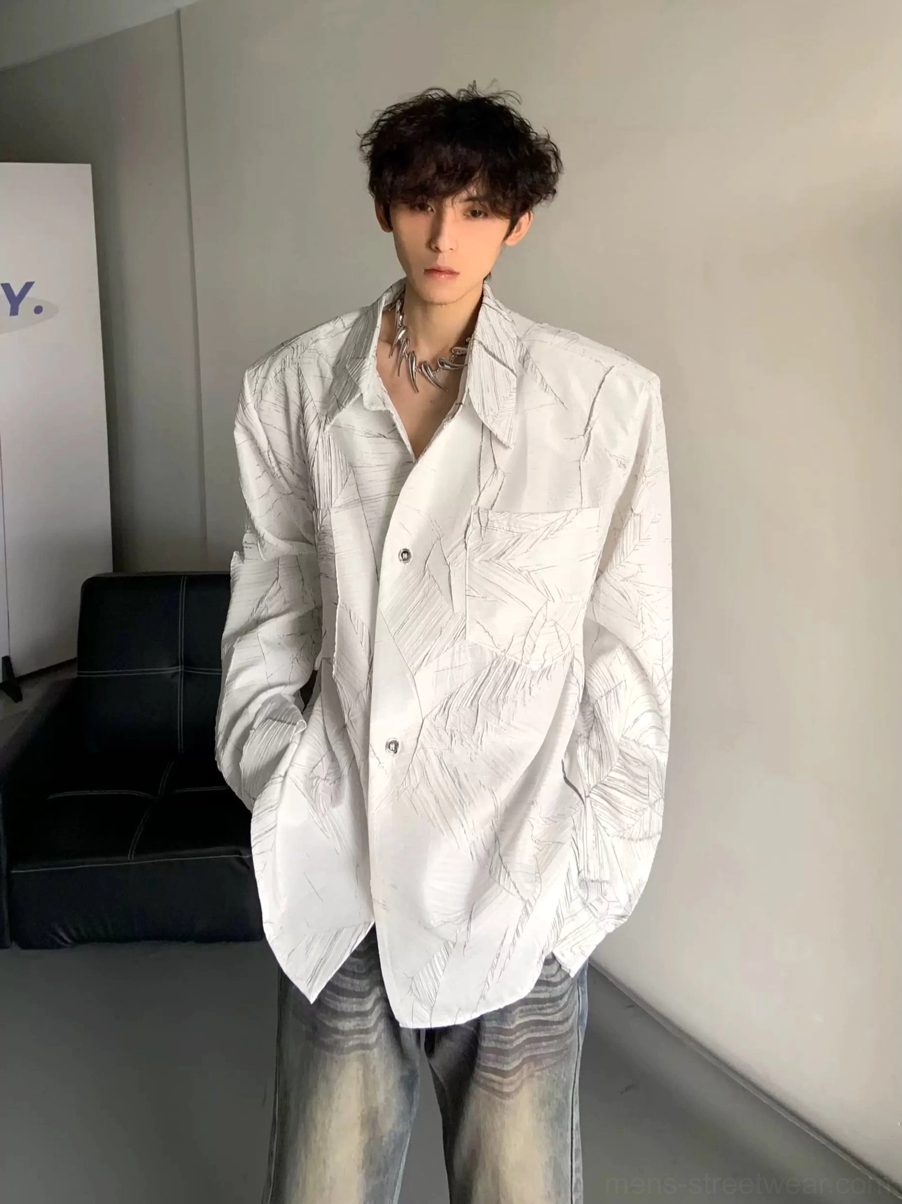 White oversized long sleeve leaf print shirt with relaxed fit styled with distressed jeans