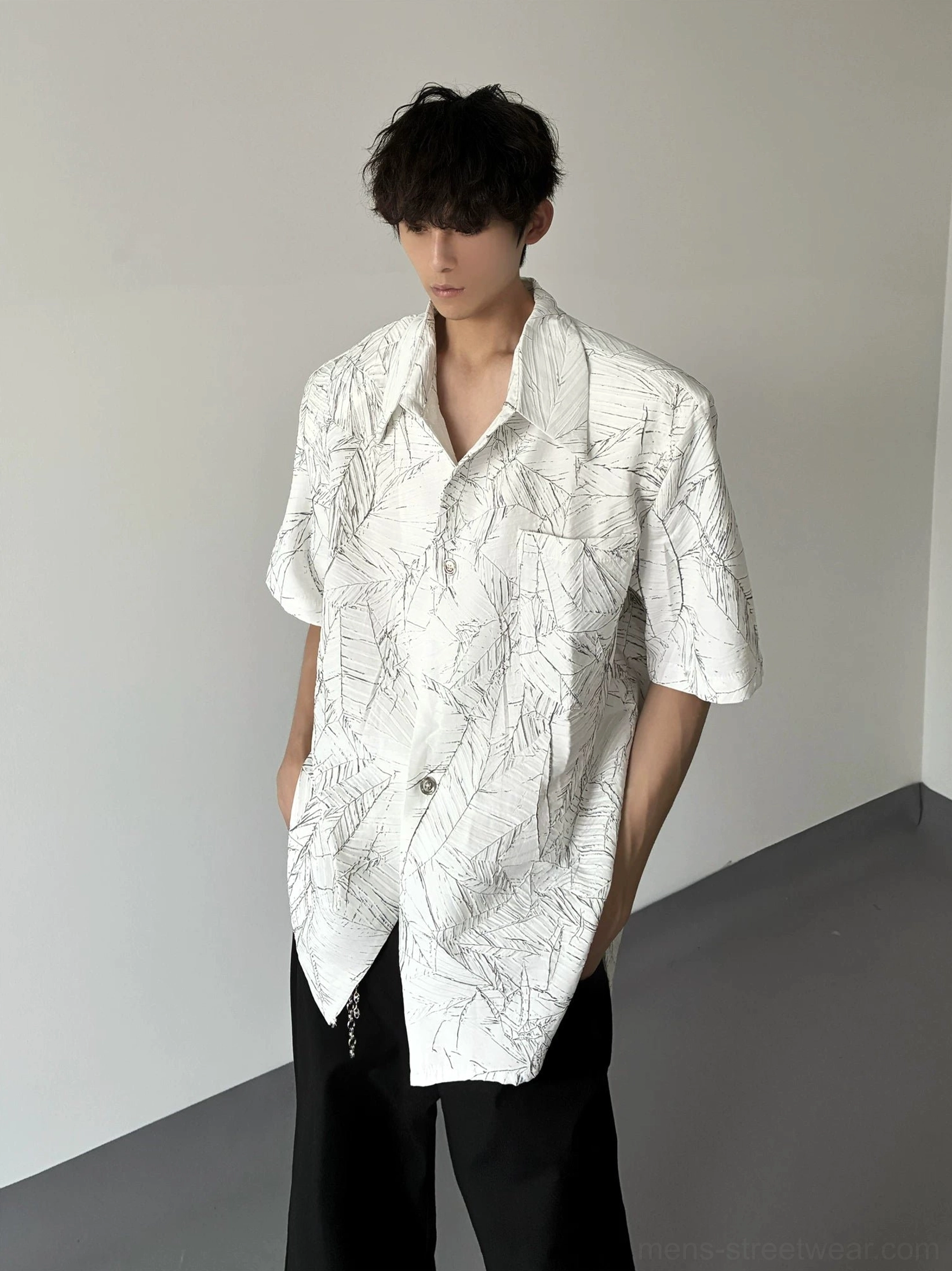 White oversized short sleeve leaf print shirt with curved hem styled with wide-leg black pants