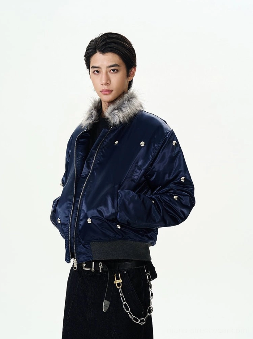 Front three-quarter view of a navy blue faux fur collar studded bomber jacket with glossy satin finish and ribbed waistband