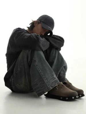 Male model wearing taupe frosted suede buckle clogs with loose denim jeans in a Korean streetwear outfit
