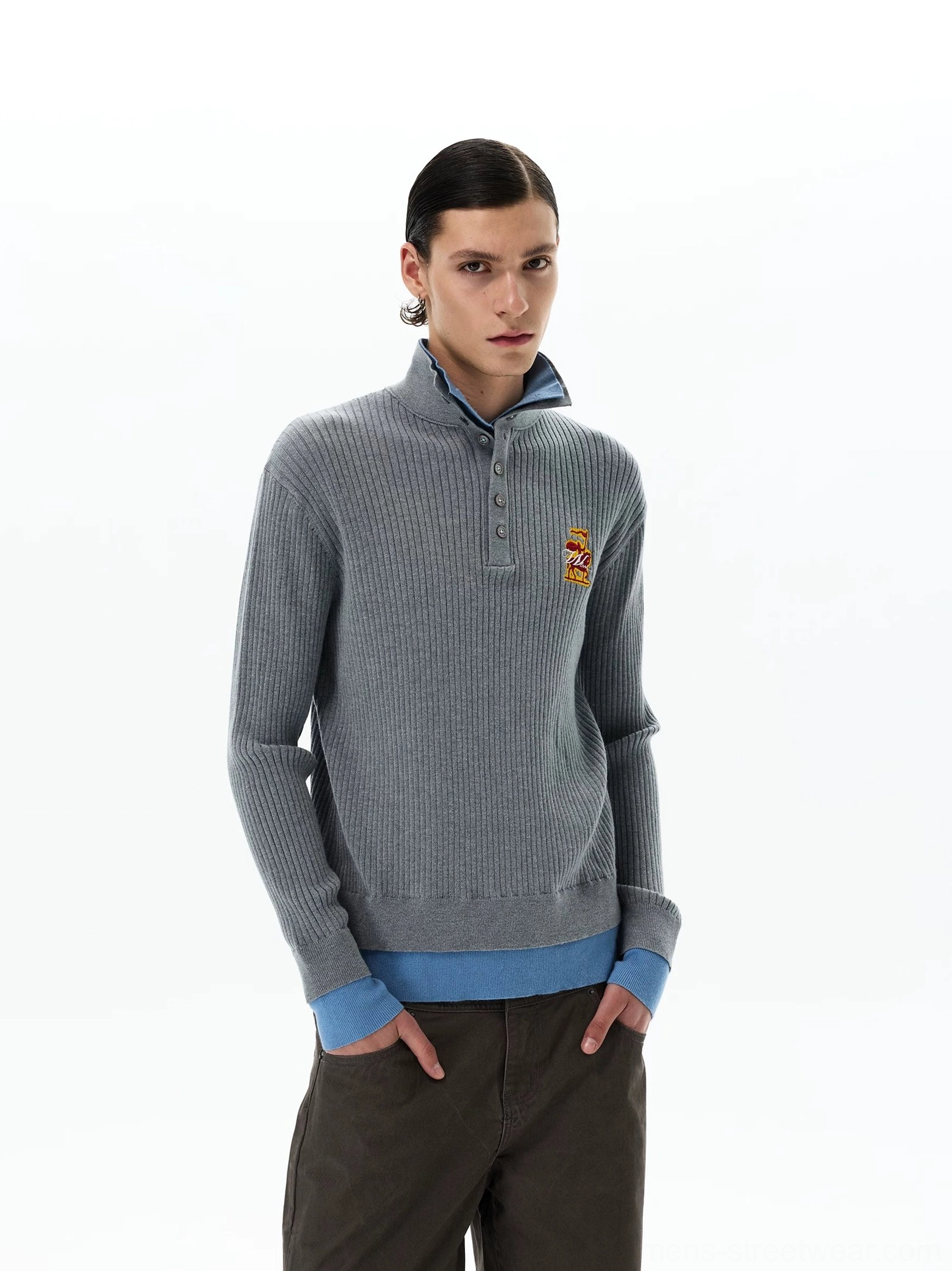 Three-quarter view of grey layered knit polo sweater for men with embroidered chest crest and sky blue contrast trim