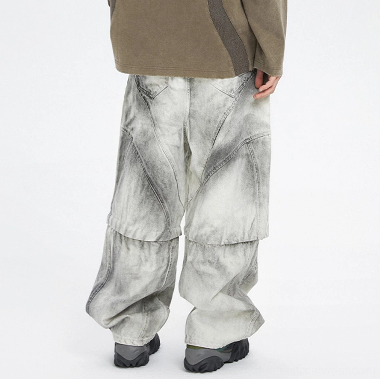 Back view of full length washed grey convertible cargo pants with loose wide leg silhouette and curved side cargo pockets