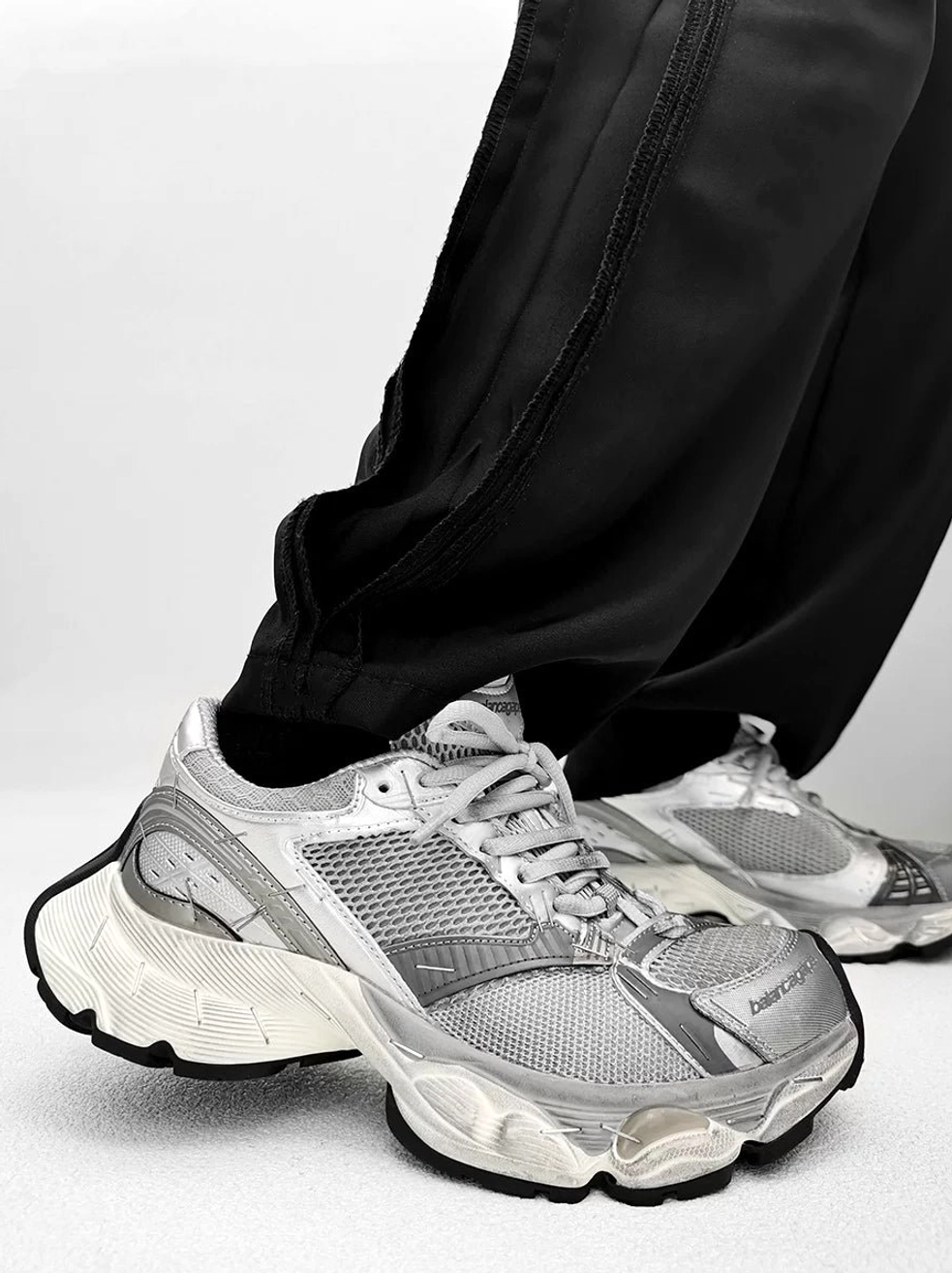 Full silver metallic chunky sneakers shown from a low side angle with mesh and synthetic upper, lace-up closure, and thick off-white sole