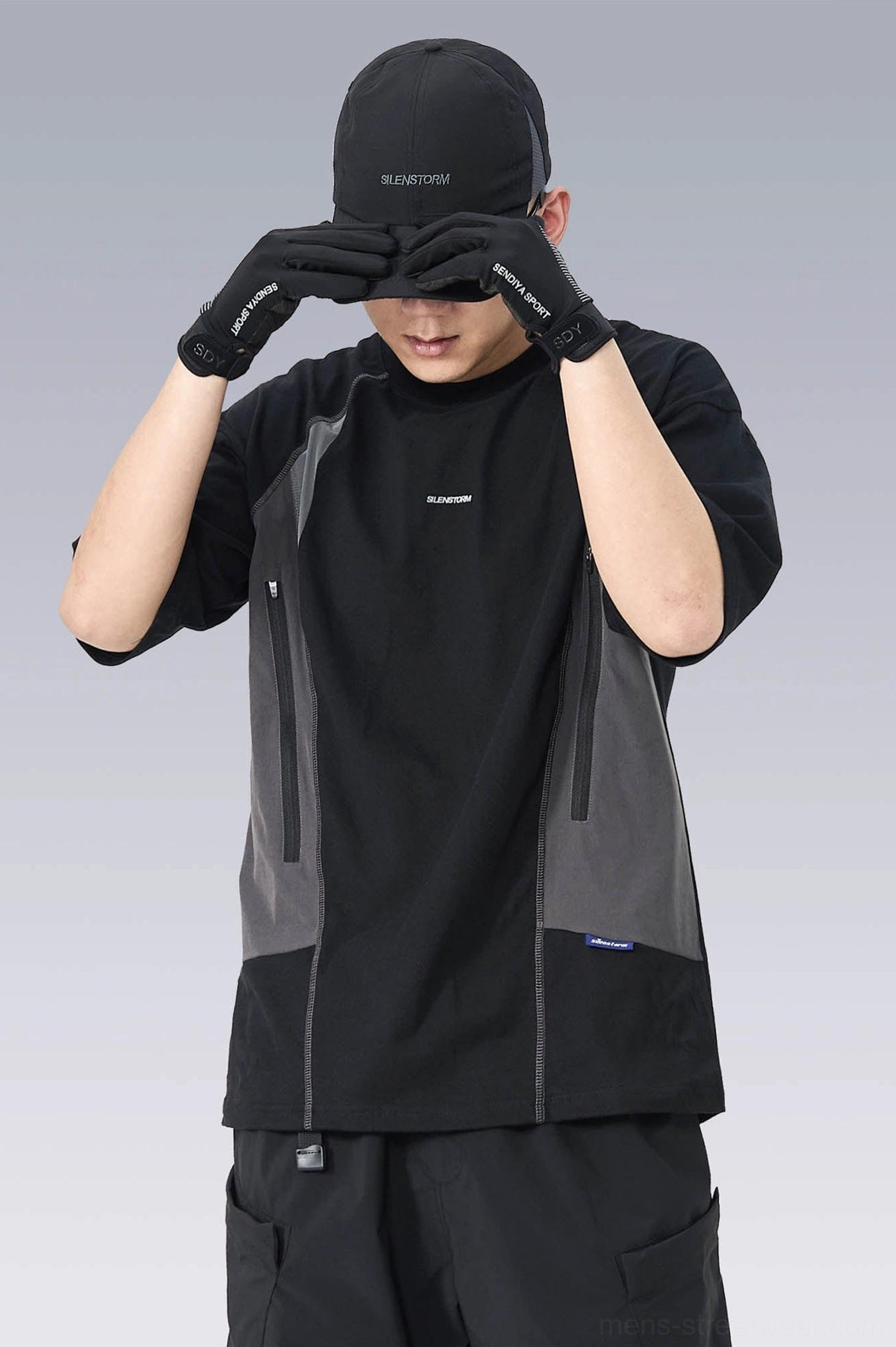 Front detail view of a functional black and grey techwear T-shirt with color-blocked panels, crew neck, gloves, and side utility zipper pocket