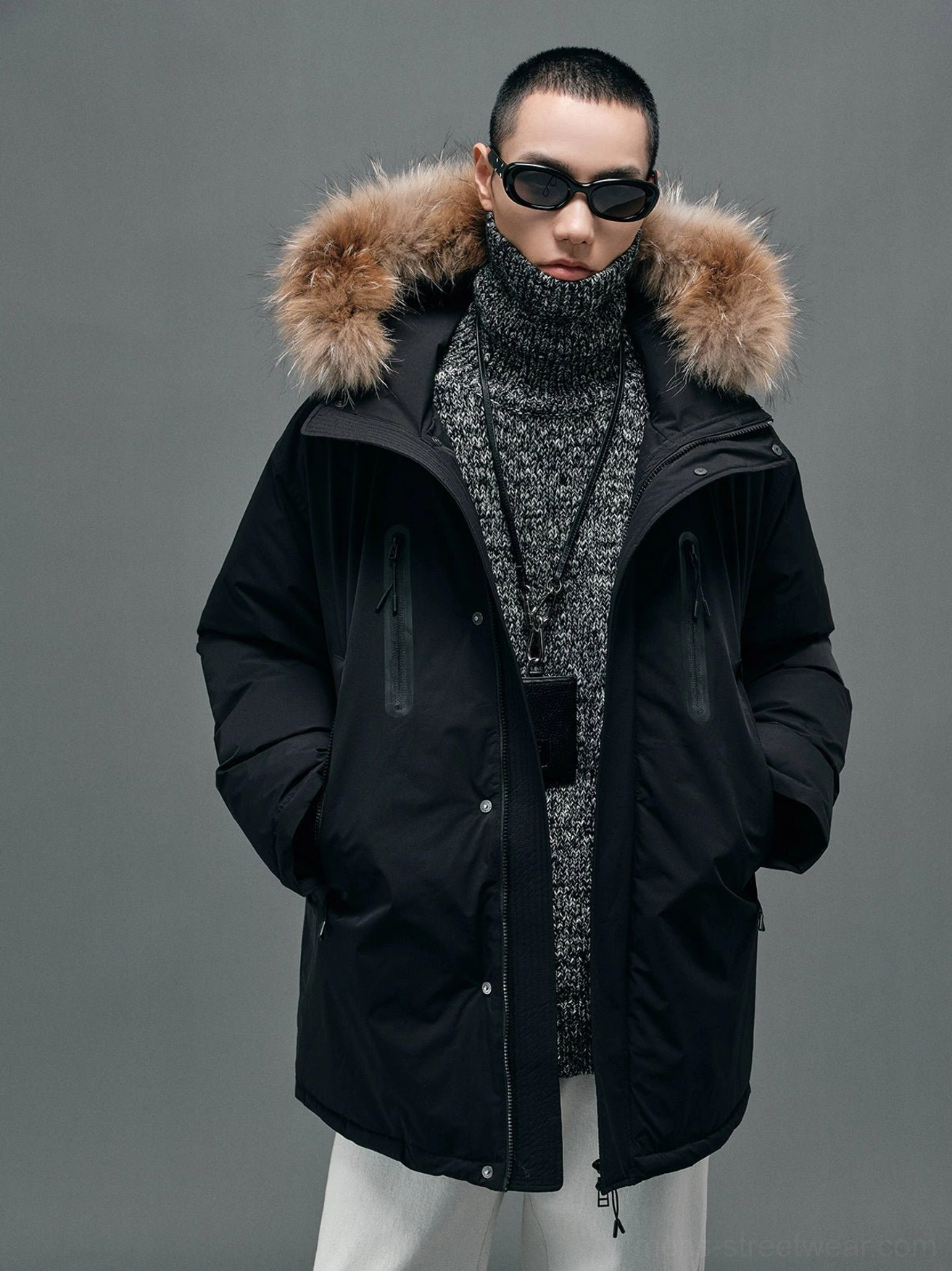 Black fur-collar hooded white duck down coat shown from the front three-quarter view on a male model in contemporary Seoul streetwear styling