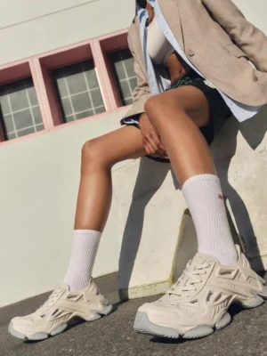 Off-white futuristic EVA platform clogs worn with white socks in an outdoor streetwear outfit