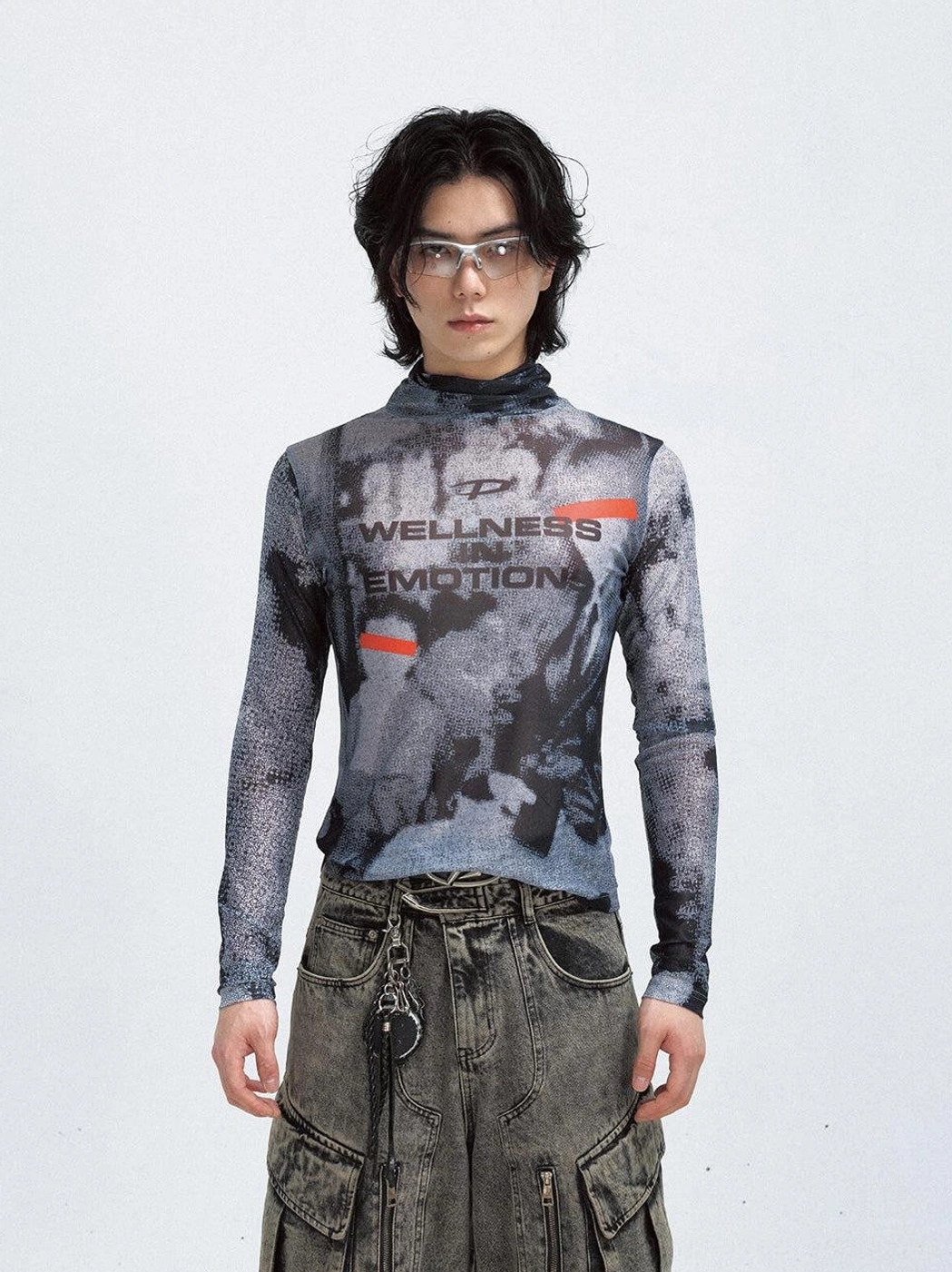 Front full-body view of a black futuristic printed mesh turtleneck sweatshirt with gray graphic pattern styled with vintage cargo jeans