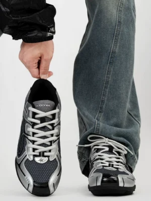 Front view of futuristic retro running sneakers with black mesh upper silver rounded toe cap and classic lace-up closure