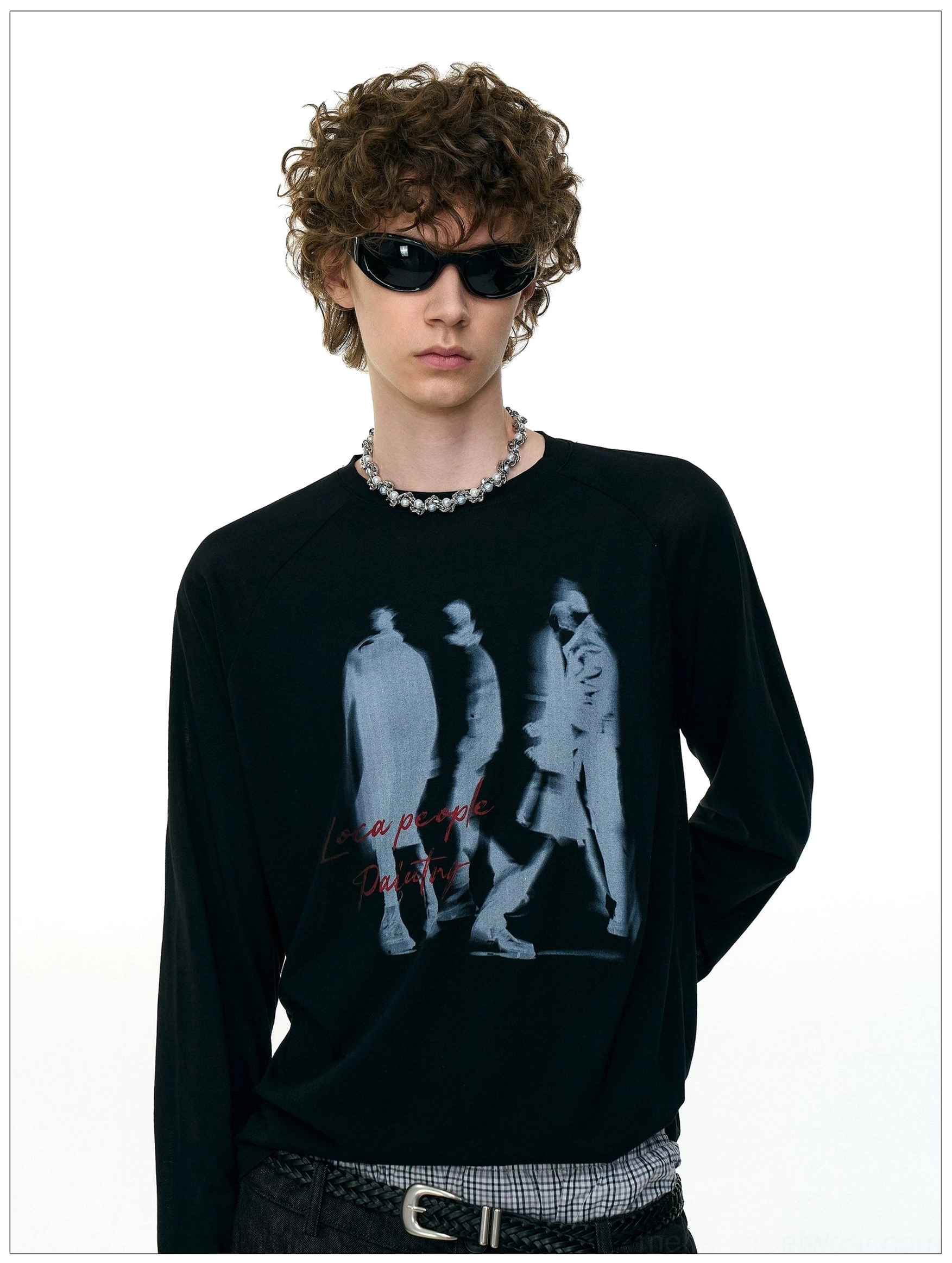 Side front view of a model wearing the black Ghost Walkers shadow graphic long sleeve tee with relaxed raglan sleeves and streetwear accessories