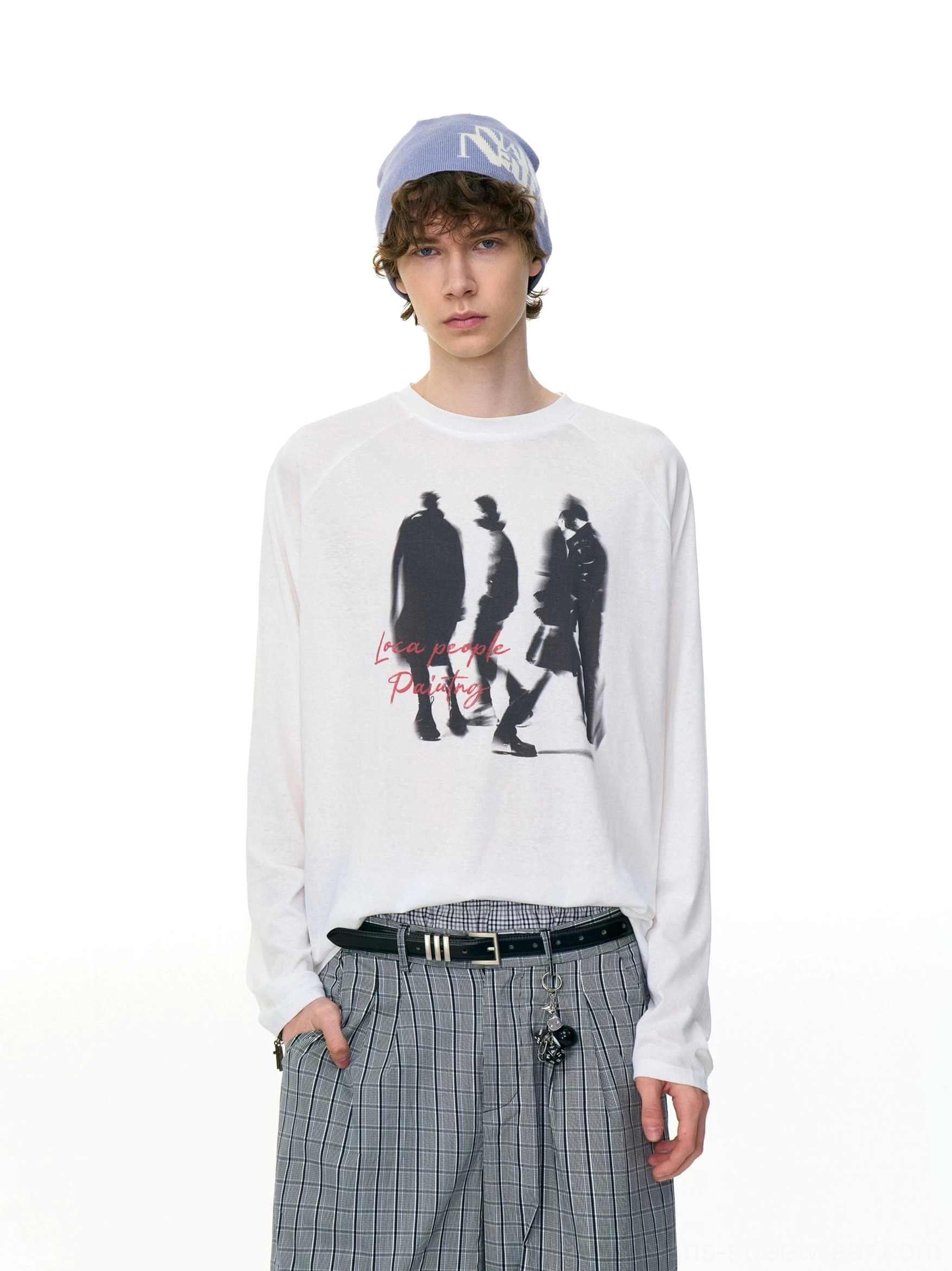 White Ghost Walkers graphic long sleeve tee with black walking silhouette print and red handwritten text styled with checkered wide-leg pants