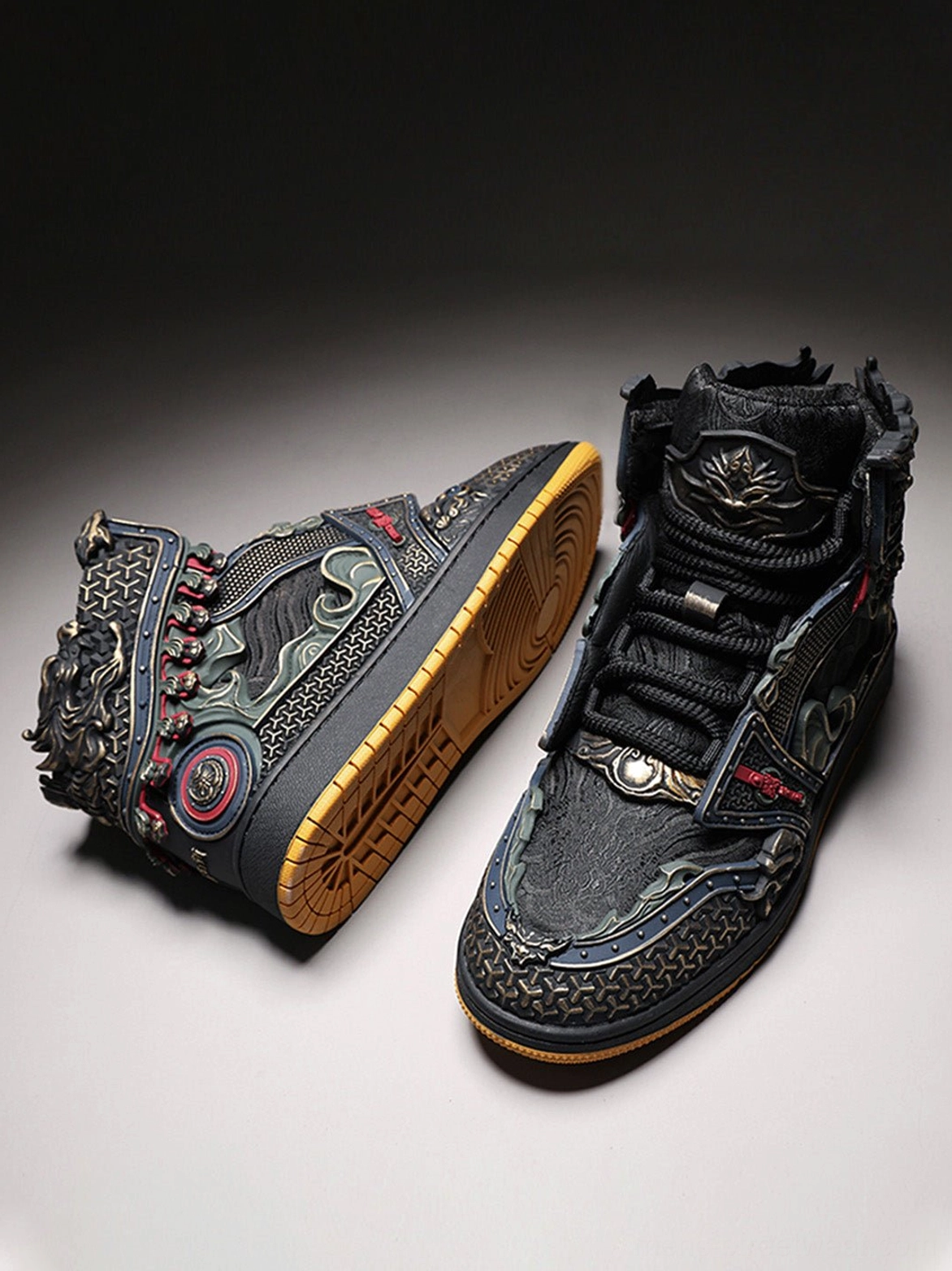 Pair of black gilded armor high-top sneakers shown from an angled top view with complete sculpted relief and gum outsole details