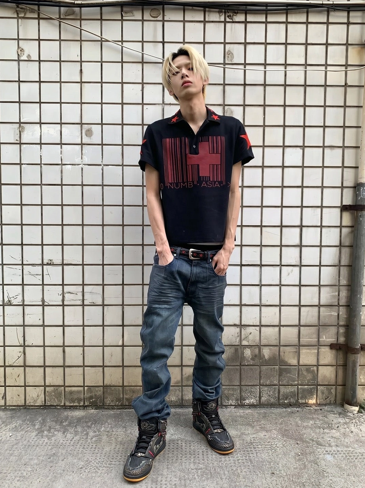 Black decorative high-top sneakers worn with jeans in a casual urban outfit, featuring red-gold armor-inspired details