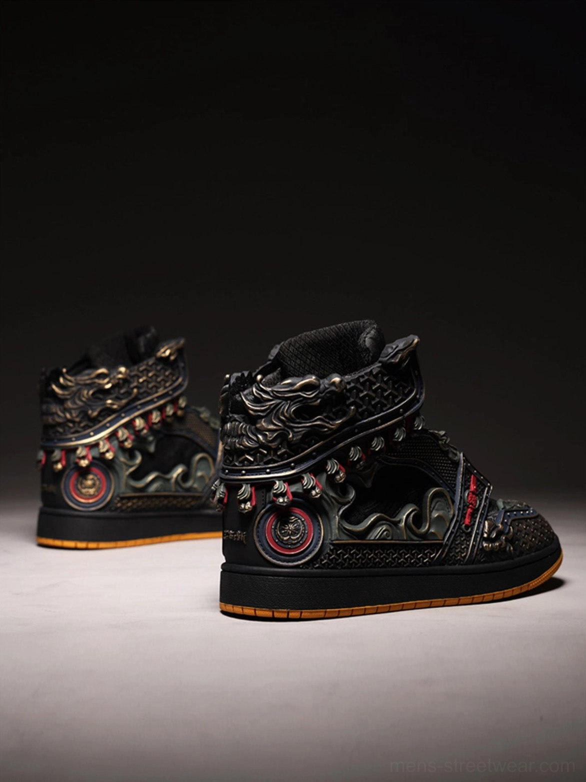 Pair of black armor-inspired high-top sneakers with heel armor panels and circular red-gold badge decorations