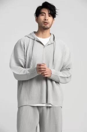 Light grey oversized Glacier Wave pleated hoodie shown in a close front view with vertical pleats and minimalist half-zip streetwear detailing