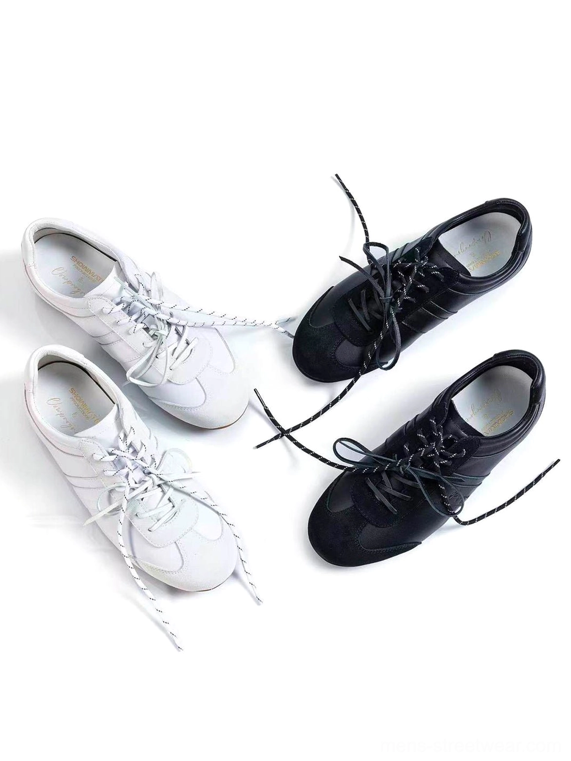 White and black gloss-finish suede leather low-profile retro trainer pairs arranged in an overhead studio view