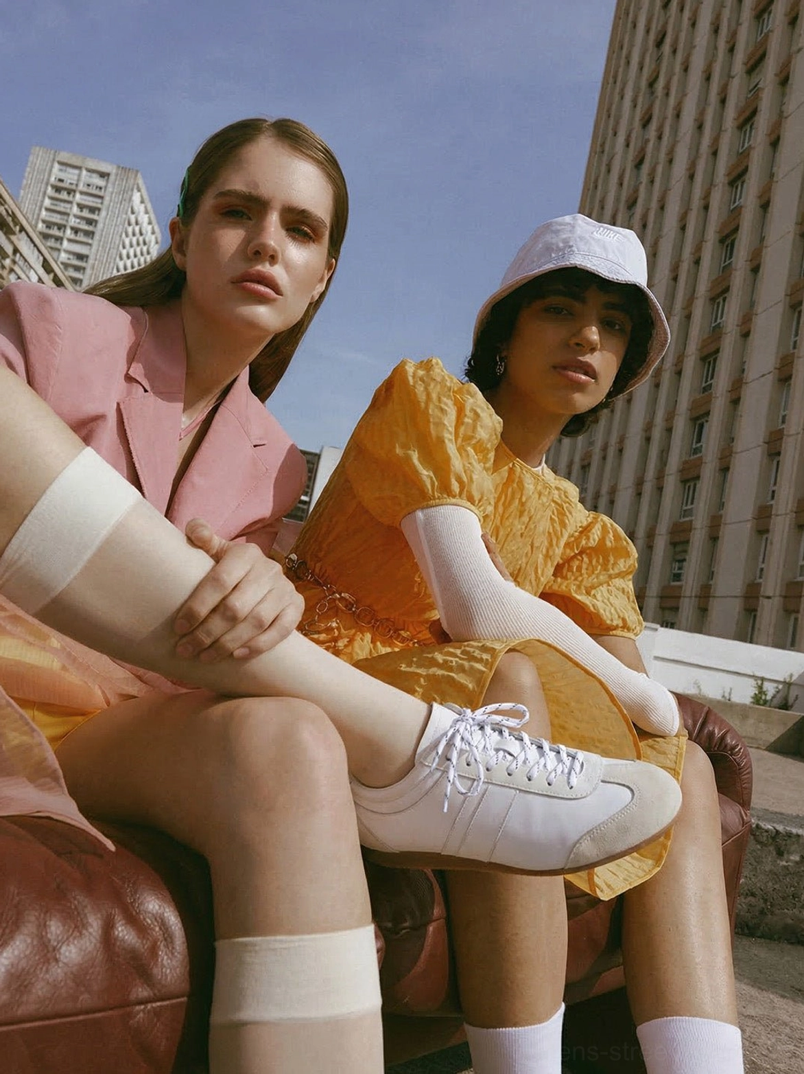 White low-profile suede leather retro trainers worn with a casual vintage streetwear outfit outdoors