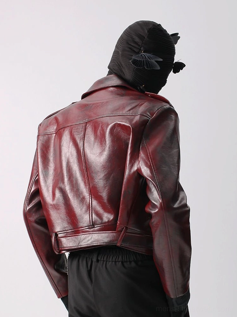Glossy crimson burgundy faux leather moto jacket rear three quarter view showing tailored back seams adjustable waist strap and fitted sleeves