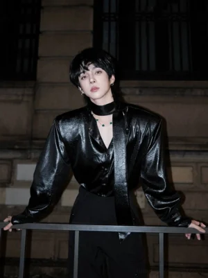 Black glossy tie-neck streetwear shirt with deep V neckline and matching neck tie styled with tailored trousers at night