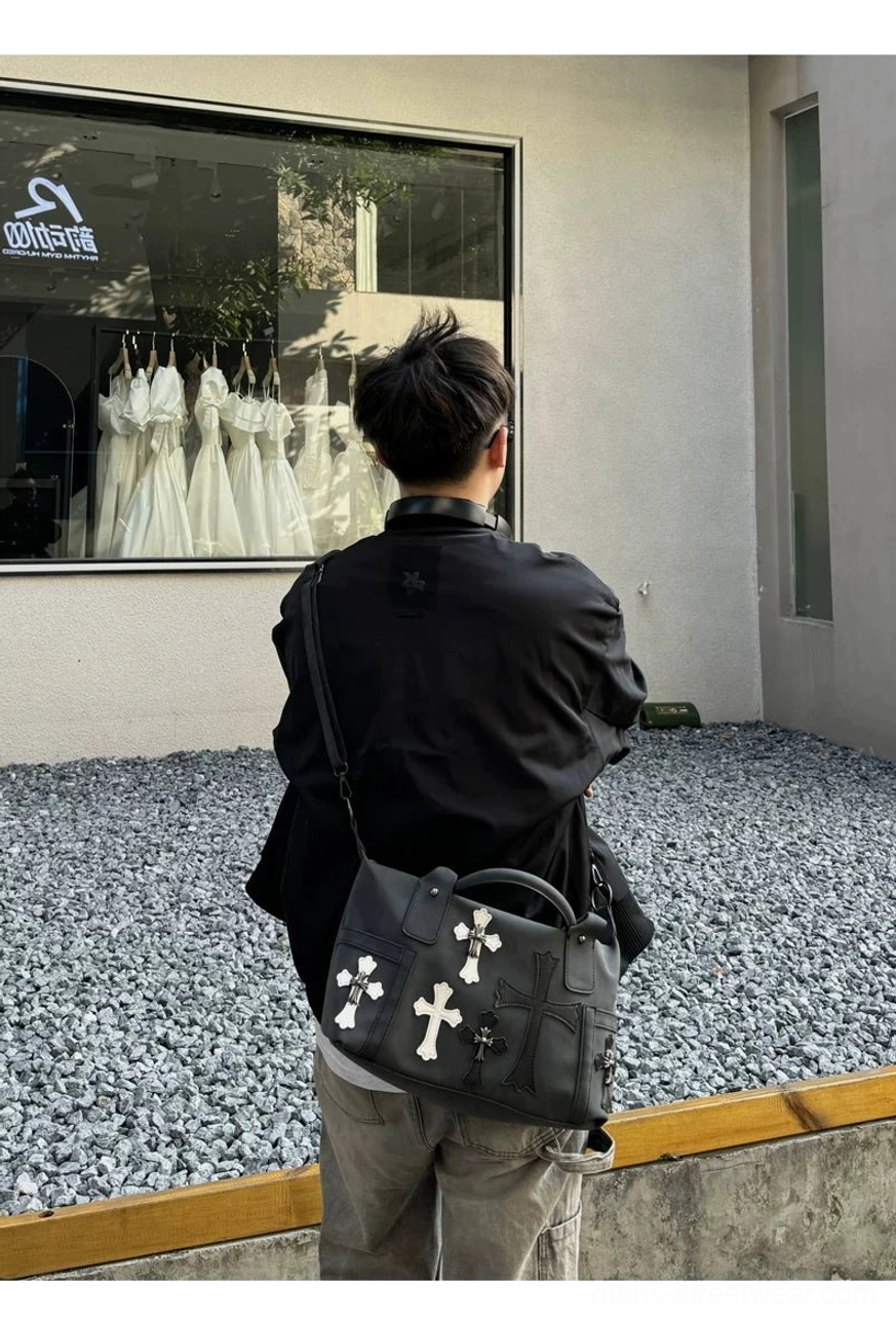 Black gothic cross PU leather satchel worn crossbody on back hip in outdoor streetwear look