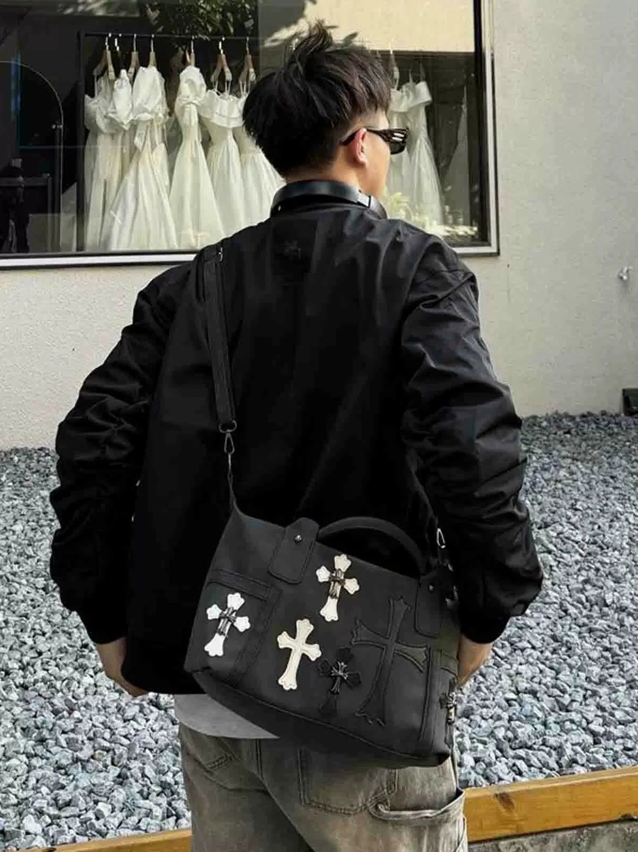 Black cross decorated streetwear satchel worn at hip from rear view showing mixed gothic cross appliques