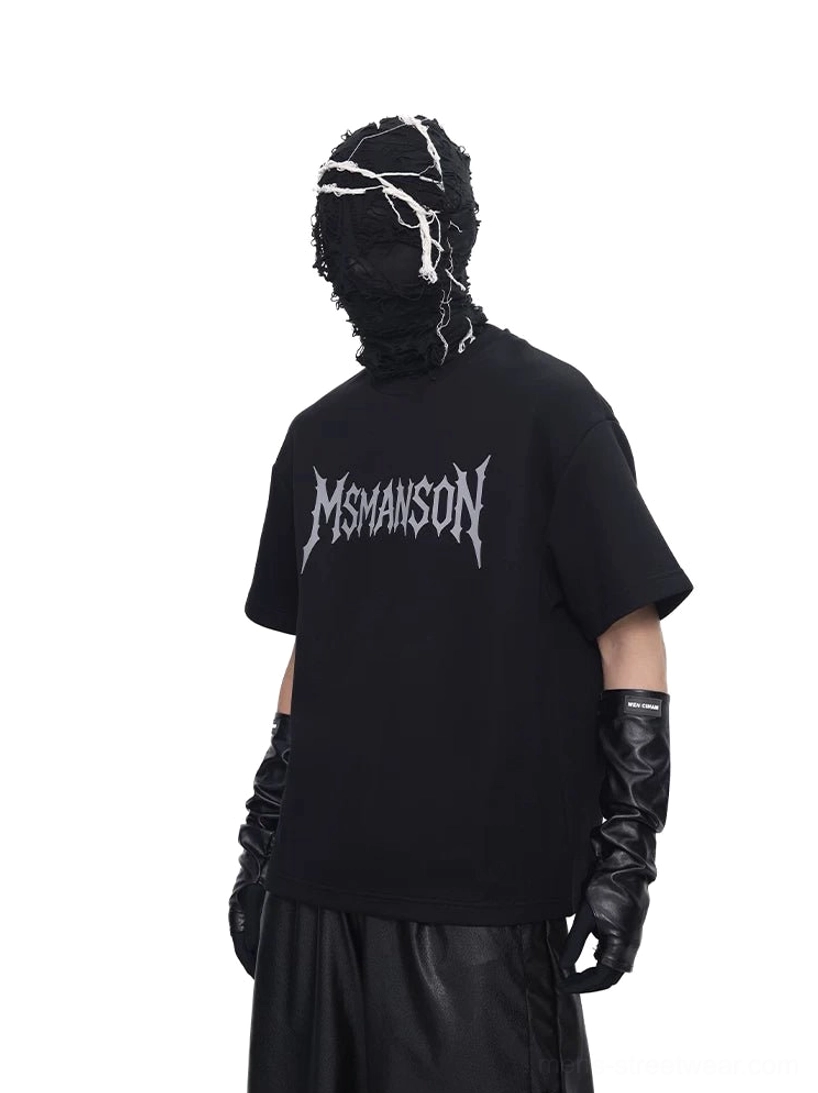 Back view of black oversized gothic script graphic T-shirt styled with wide-leg pants and leather gloves in a dark Korean streetwear look
