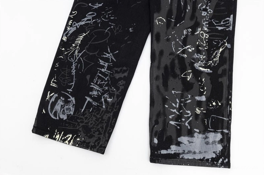 Wide-leg graffiti denim jeans artistic detail showcasing mixed typography tags and abstract graffiti elements on premium black denim streetwear