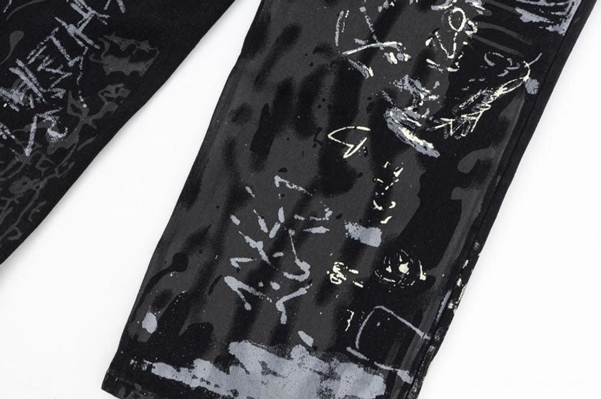 Single pant leg detailed close-up showcasing bold abstract ink blocks and hand-drawn decorative linework on graffiti-print black denim