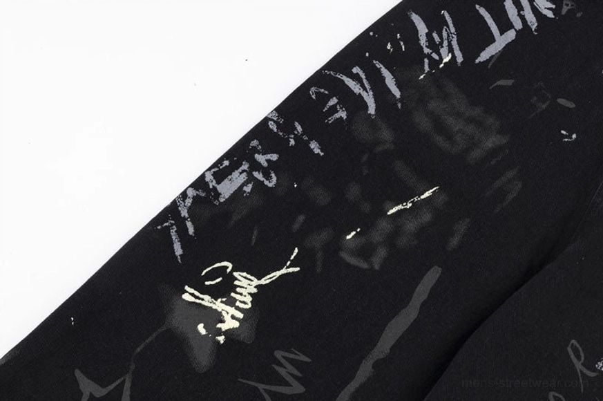 Pant leg detail featuring signature-style handwritten graffiti lettering and abstract ink stroke patterns on premium black denim streetwear