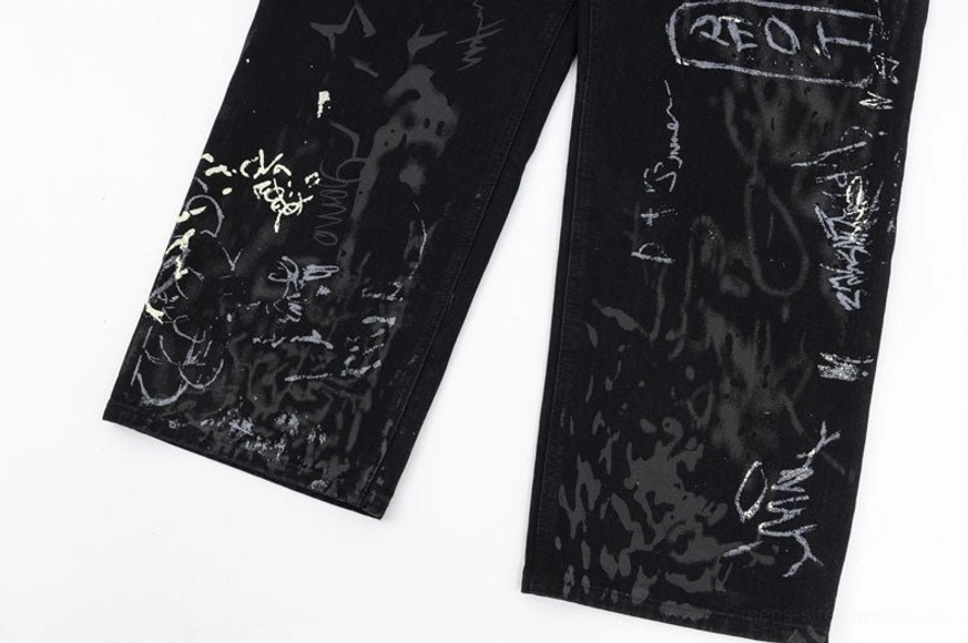 Graffiti art wide-leg jeans flat lay showing high-waisted relaxed fit silhouette with all-over hand-drawn splatter ink design coverage