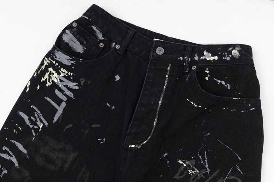 Waist and front pockets close-up view of graffiti-print jeans with slant pockets button zipper fly and artwork coverage on streetwear denim