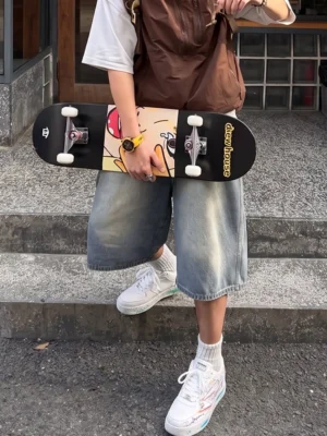 Graffiti lightning court sneakers worn with denim shorts in an urban stairway outfit, showing colorful unisex Korean streetwear styling