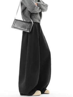 Matte black oversized cocoon trousers side three quarter view showing fluid super wide leg streetwear fit