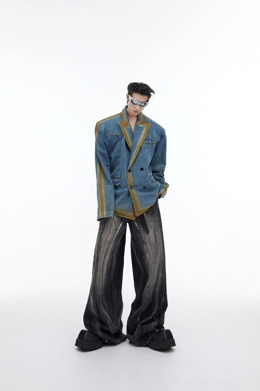 Front styling view of graphite black distressed flared wide leg jeans paired with a worn blue denim blazer and sunglasses