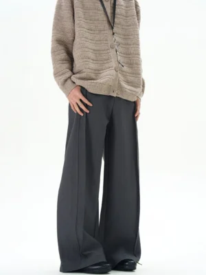 Dark gray ultra-wide draped trousers in a front three-quarter view with vertical seams, relaxed tailoring, and Korean streetwear styling