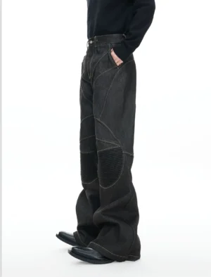 Left side view of black reinforced flare denim jeans showing wide leg silhouette side pocket and structured ribbed knee panel