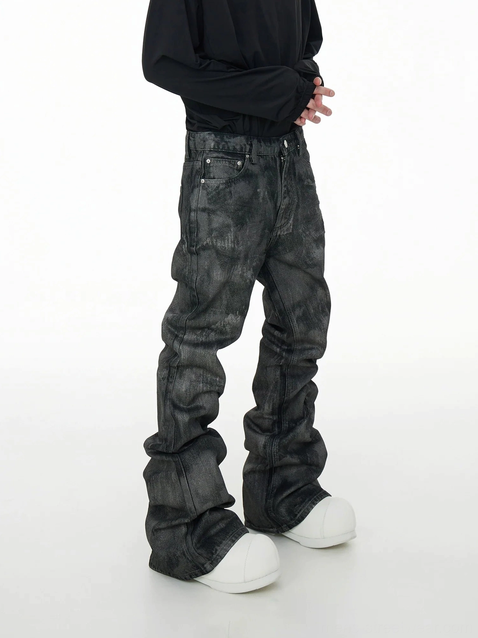 Right side view of gray acid wash stacked jeans showing the waistband, button fly, extra-long hem, and dramatic streetwear proportions