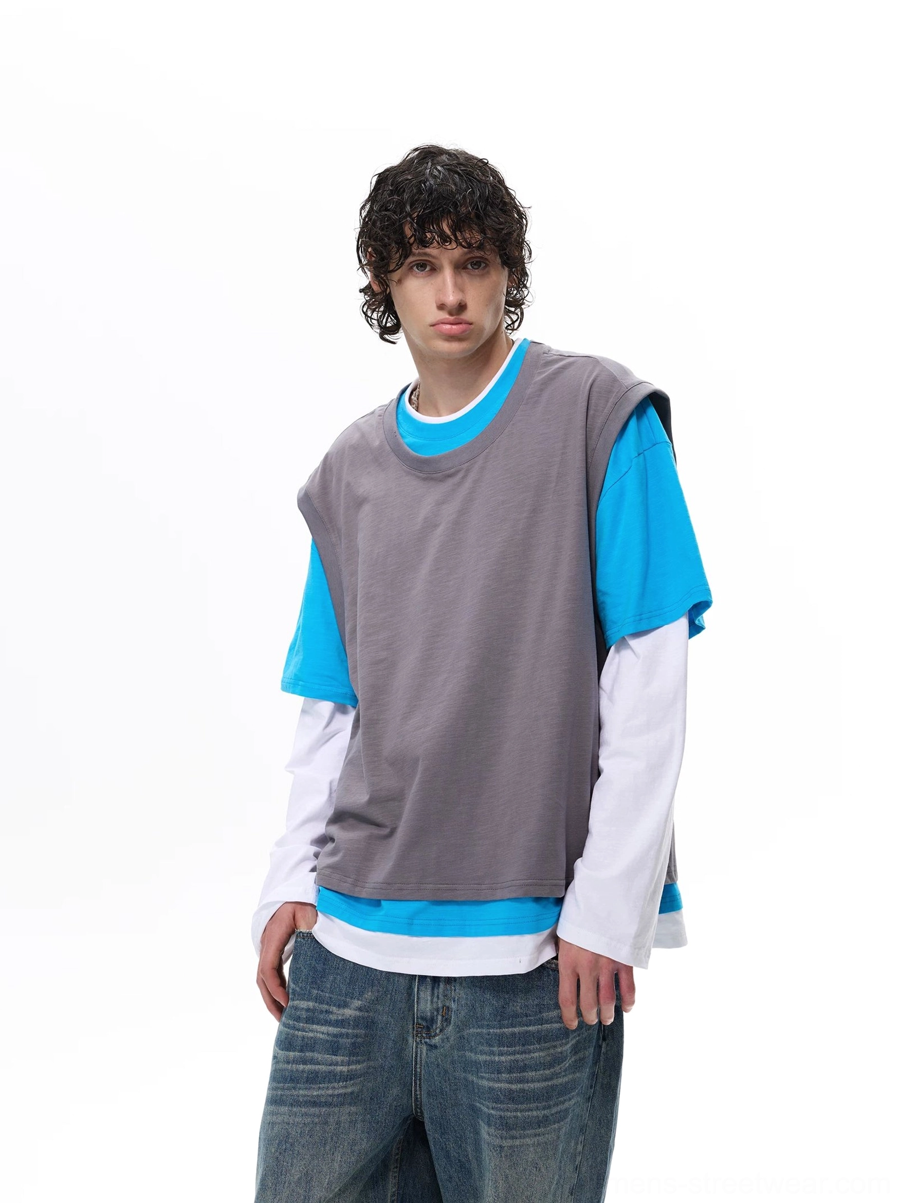 Front view of a gray blue and white faux layered vest tee top styled with loose washed blue jeans for a Korean streetwear outfit
