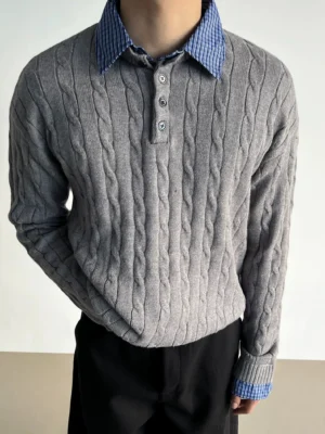 Heather gray cable knit polo sweater with blue gingham shirt collar and cuffs styled with black trousers in studio
