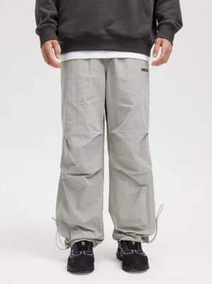 Gray crinkled wide-leg drawstring track pants shown from the front with relaxed Korean streetwear styling and sneakers