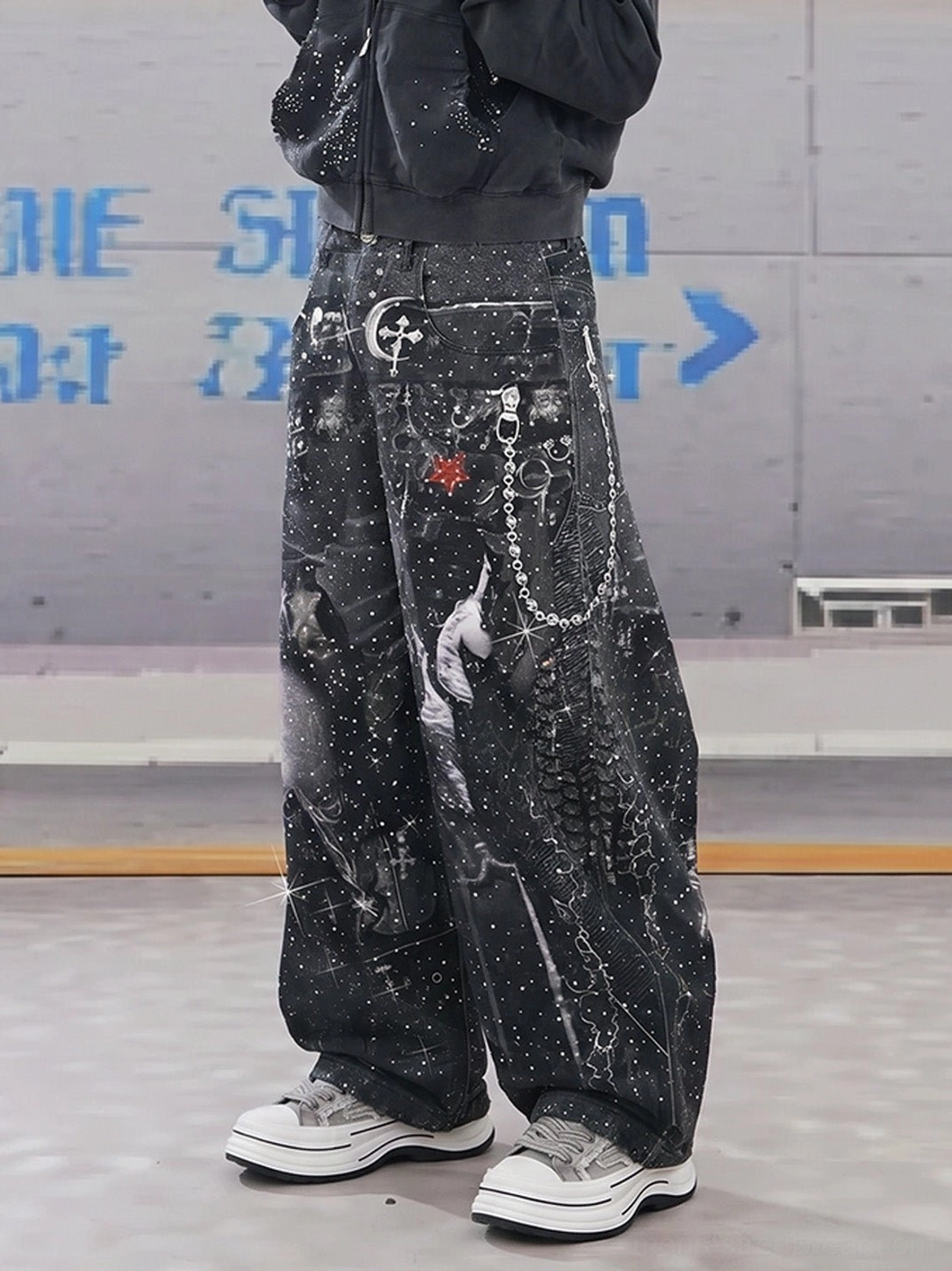 Rear view of gray frayed canvas platform sneakers worn with a cropped black jacket, embellished wide-leg jeans, and chain streetwear accessories