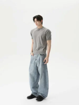 Heather gray solid knit short sleeve crew neck T-shirt styled with wide leg blue jeans and black leather shoes in a minimalist Korean streetwear outfit